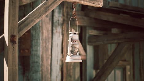 old rusty lantern hanging on a wooden structure