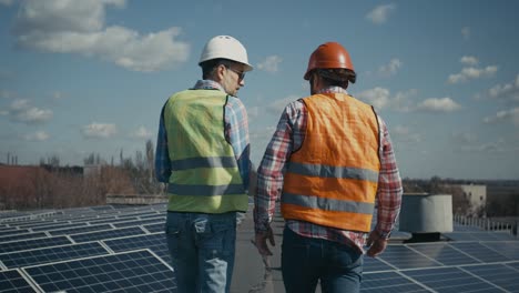workers inspecting solar panels on a rooftop