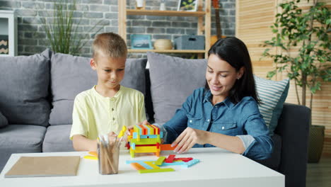 mother and son building with colorful blocks