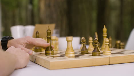 close up of unrecognizable father and son playing chess outdoors