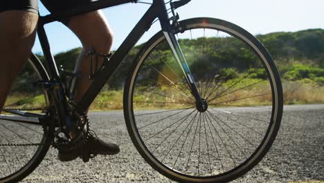 Hombre-Triatleta-En-Bicicleta-Por-La-Carretera-Rural.