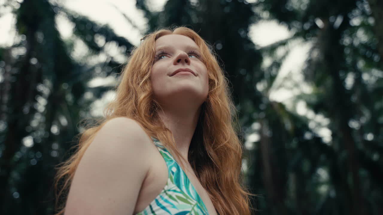 Redhead Woman Looking Up at Trees