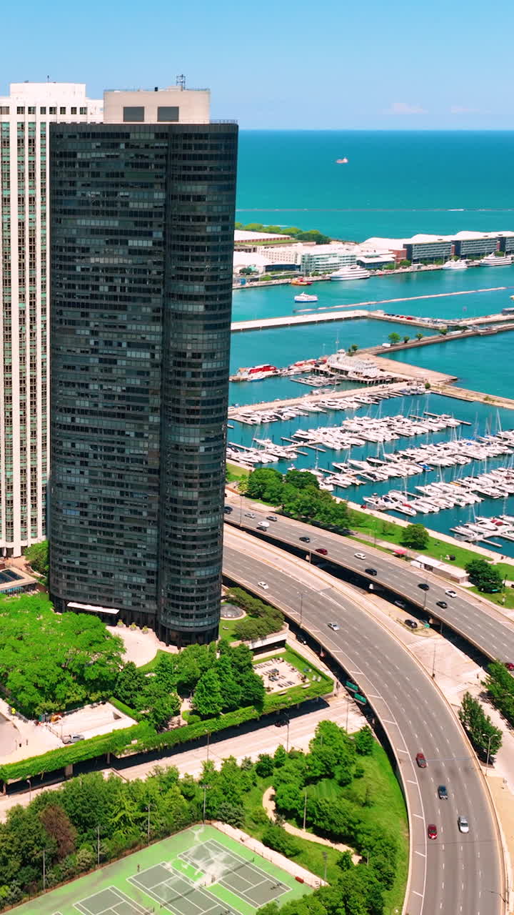Vista aerea del centro di Chicago. Lake Shore Drive. Traffico intenso di auto lungo l'argine del lago Michigan. Yacht nel porto. Video verticale