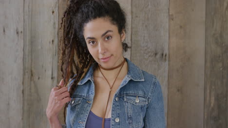 portrait of beautiful young mixed race woman smiling happy playing with hair wearing dreadlocks hairstyle cute female denim fashion slow motion