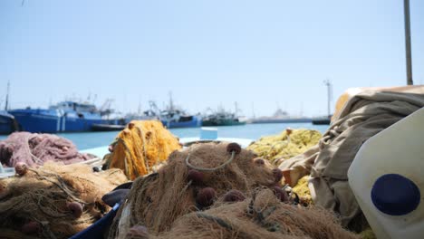 fishing nets rest on the deck of a fishing boat on a sunny day in the marina