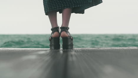 Along the Blue-Green Lake, a woman walks in her tall black shoes and emerald green dress. Asian fashion style against the eerie green water of Lake Michigan