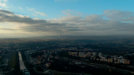 aerial view of pine trees forest on cold winter morning with early warm sunlight european city