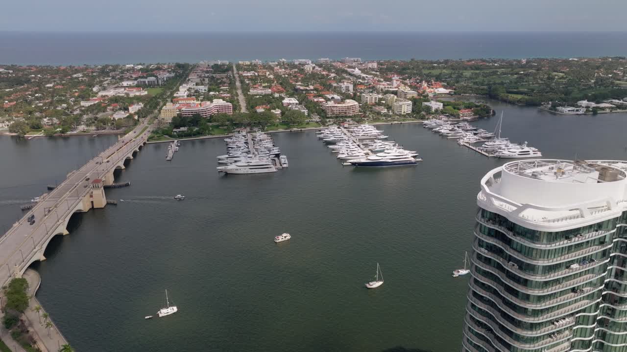 Aerial view of a coastal city with a large yacht marina and bridge