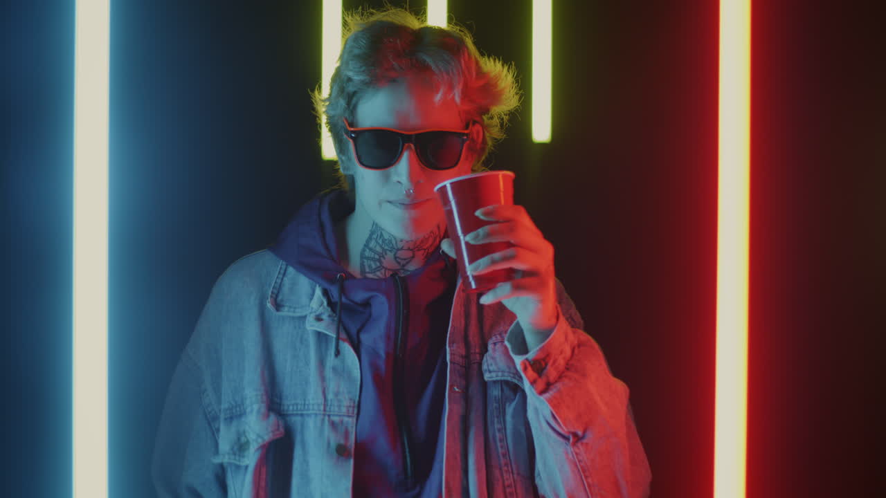 Stylish woman enjoying a drink under neon lights