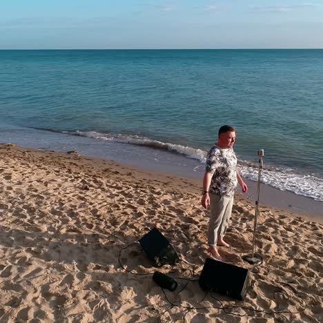male singer on a sea beach in summer. musician standing on a sand shore and singing alone on a beautiful background of sea nature in sunny day