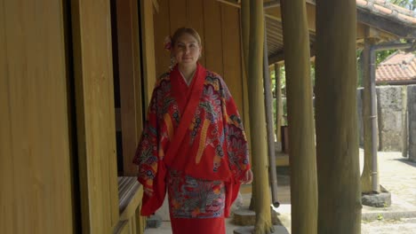 Beautiful-latin-young-woman-wearing-traditional-ryusou-kimono-dress-at-Okinawa-world-naha-japan-at-wooden-house-in-summer-day