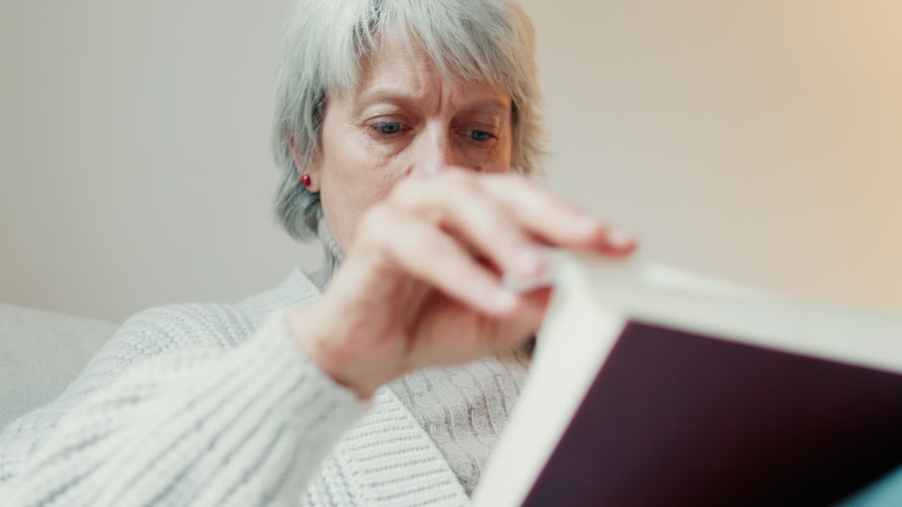 Senior woman reading a book at home