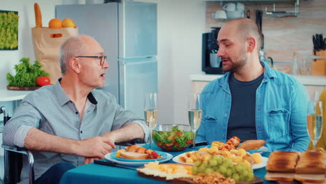 man in wheelchair having dinner