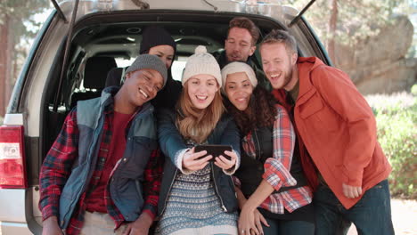 un grupo de seis amigos toman una selfie en un hatchback de coche abierto