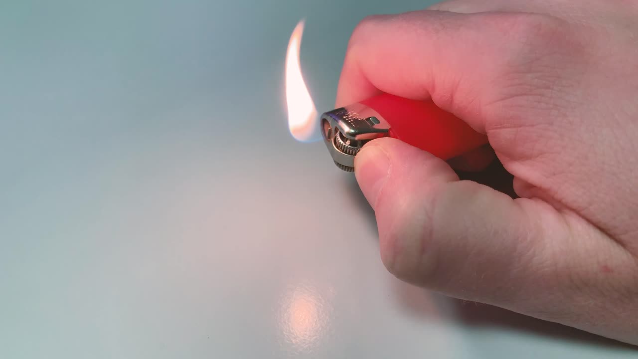 encender un encendedor rojo, contra un fondo claro