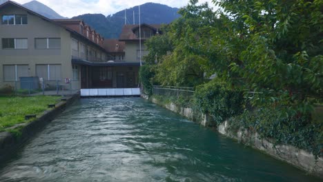 interlaken pov inmersivo: moverse por las calles de la ciudad temprano en la mañana en suiza, europa, caminando | movimiento tembloroso desde el pequeño camino hasta el puente frente al agua