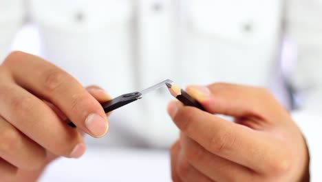 male student sharpening pencil for education