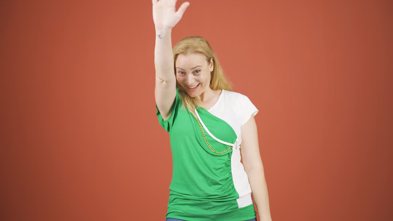 카메라를 향해 손을 흔들고 있는 행복한 여성