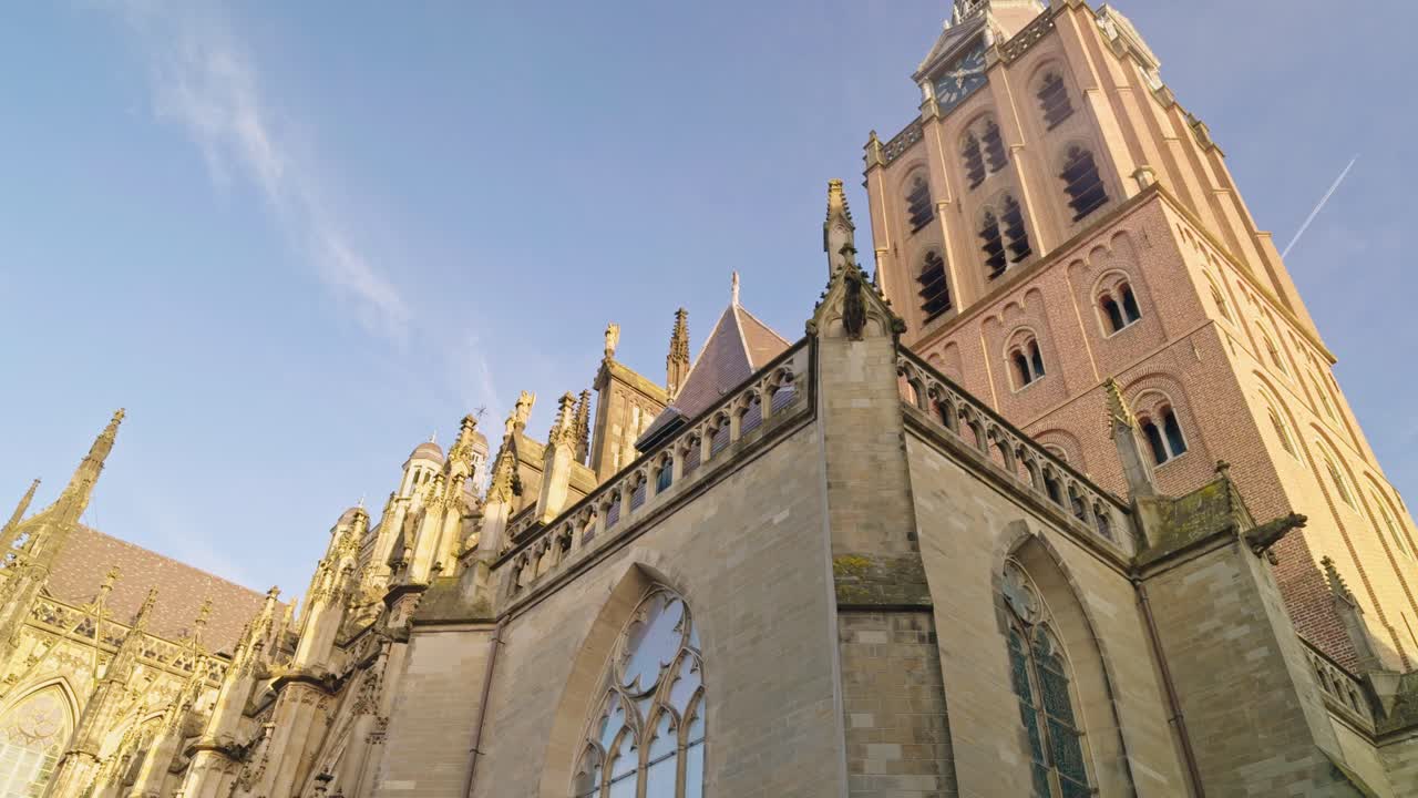 Saint John's Cathedral in 's- Hertogenbosch Den Bosch in Netherlands, low angle view of the building chapel, blue sky and spires, authentic traditional Dutch European architecture style design