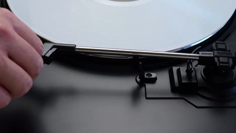 placing white vinyl record on a turntable. spinning white lp on a turntable. process of preparing album for listening on a gramophone