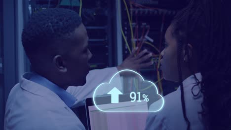 animación de la nube con carga sobre hombre afroamericano trabajando en una computadora portátil en la sala del servidor