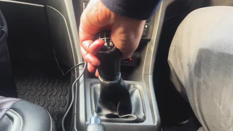 wide shot of a hand shifting gears of an indian car during a day trip