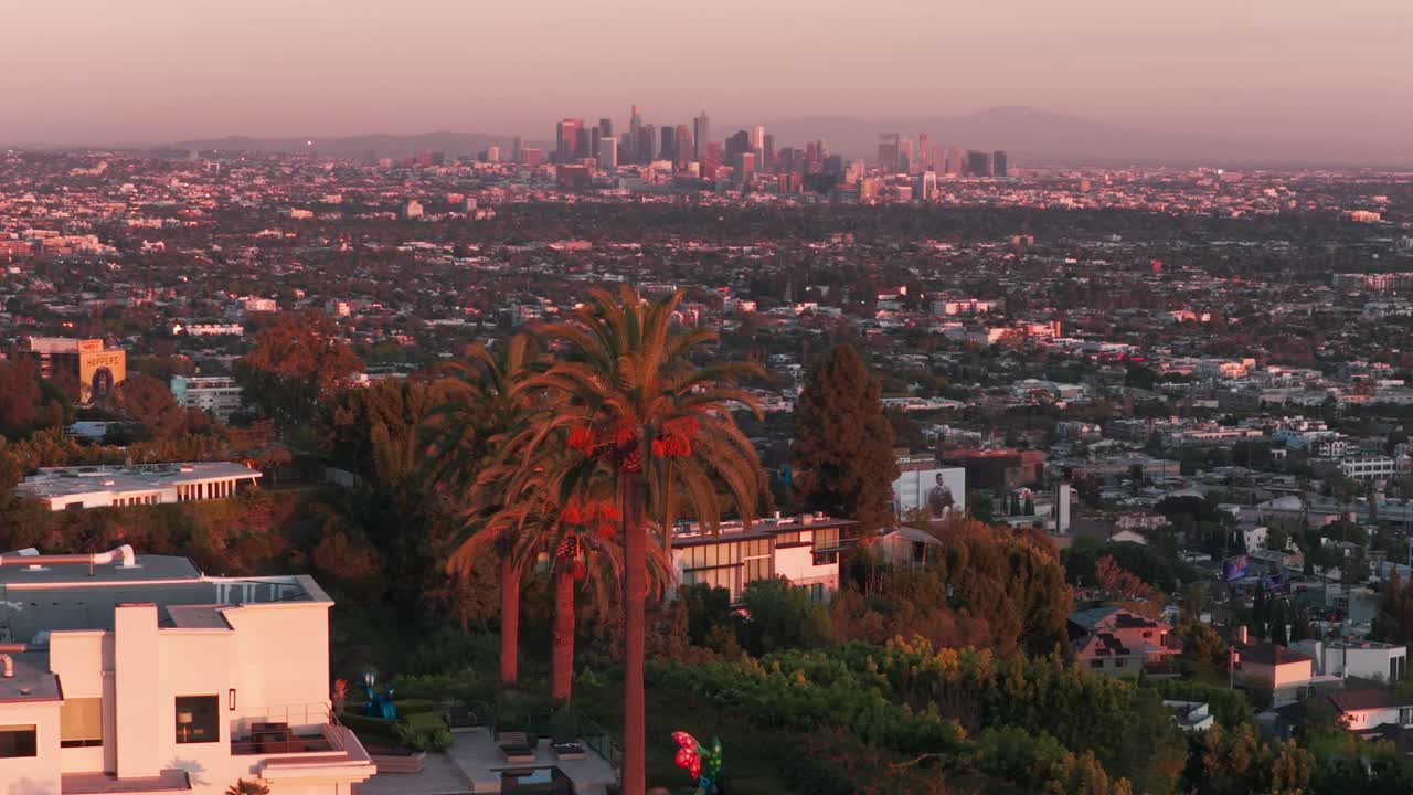 Scatto aereo a bassa quota con teleobiettivo del centro di Los Angeles dalle Hollywood Hills all'ora magica a West Hollywood, California. 4K