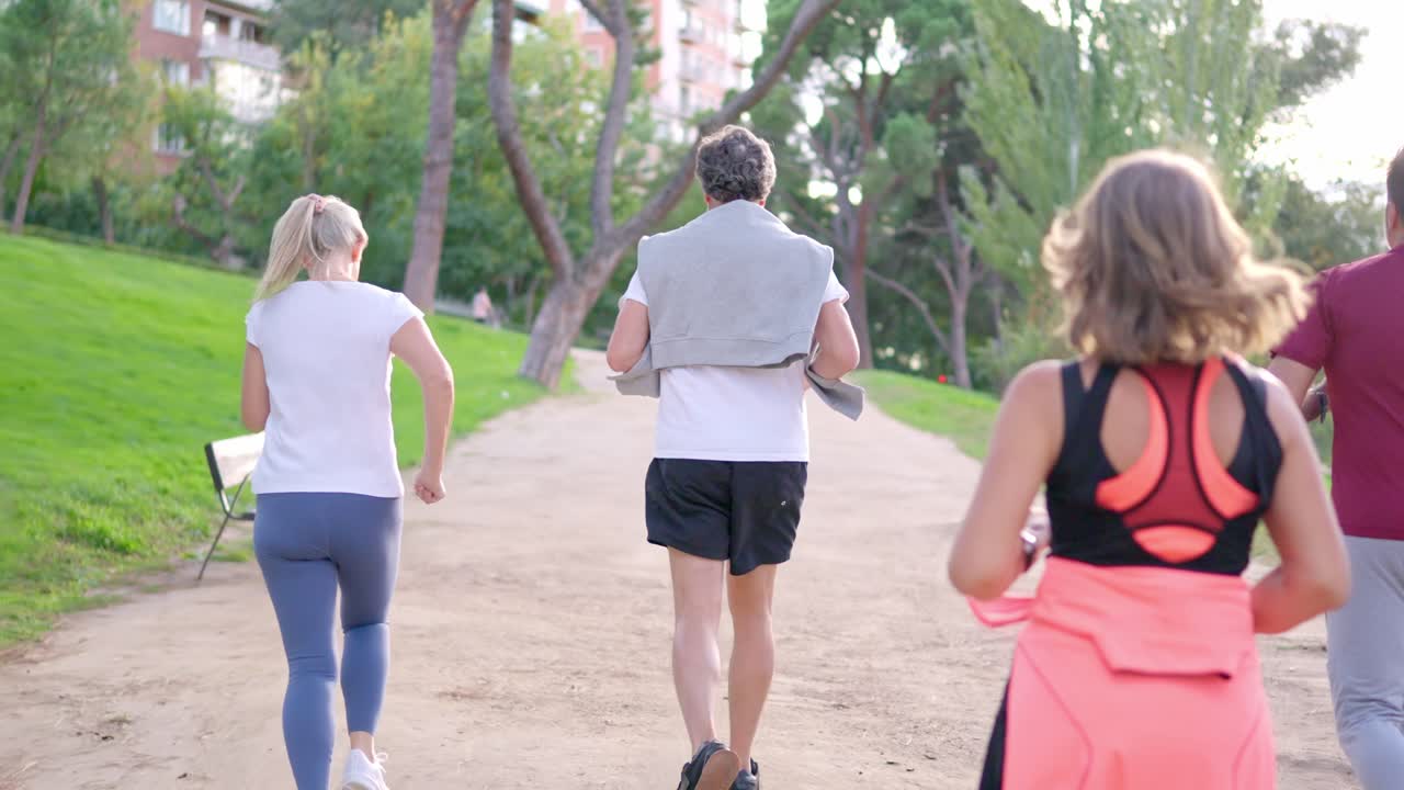 Gruppo di adulti che corrono insieme su un sentiero sterrato in un parco