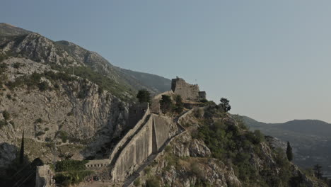 wide angle view of the ancient walls along the mountains in kotor, montenegro.the bembo bastion and the gurdic bastion ramparts climb up to the top of the st. john mountain that backs the city