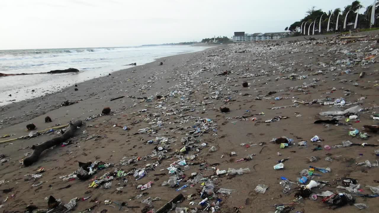 Walking over plastic trash on the beach, ecological disaster in Bali, as the man kind polluting the oceans