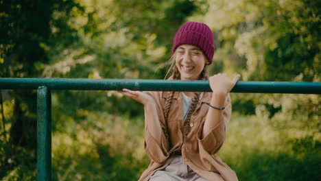 Happy-Young-Female-Tourist-Sitting-On-Railing-In-Forest