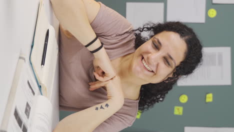 vídeo vertical de una estudiante saludando a la cámara.