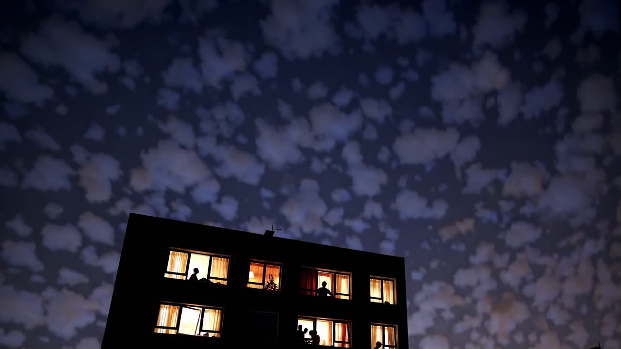 Condominio di notte con persone alle finestre