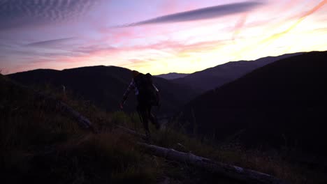 Wandern-In-Der-Wildnis,-Rucksacktourist,-Mann,-Der-In-Richtung-Bergblick-Auf-Den-Sonnenuntergang-Geht