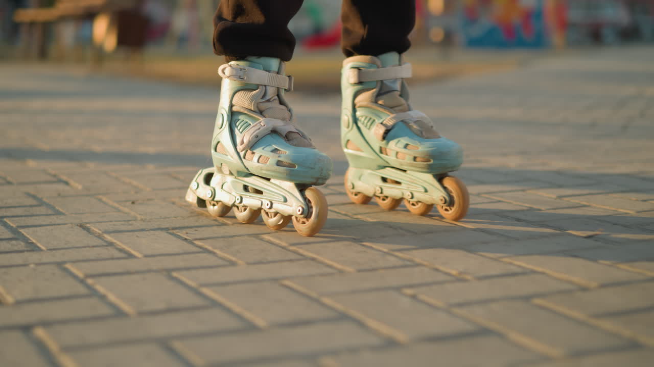 A close-up shot capturing a person s feet wearing rollerblades, smoothly gliding along a paved path in a park. with a soft focus on the background