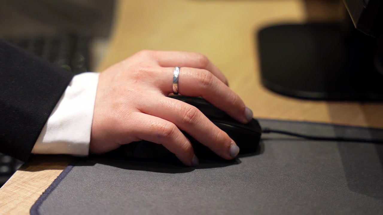 Closeup of a hotel receptionist's hand working on a computer at the front desk