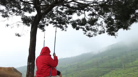 a portrait of a man swinging on a hilltop