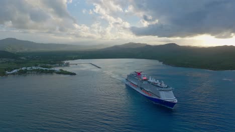 cruise ship exiting amber cove port at dusk with exotic and romantic landscape in background, puerto plata in dominican republic