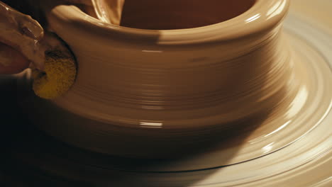 potter shaping clay on a pottery wheel