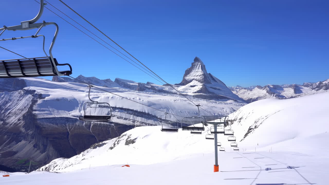 Karlı Alp Yamaçları Üzerindeki Telesiyej, Açık Mavi Gökyüzü, İkonik Matterhorn Zirvesi, Kablo Üzerinde Kayarak İlerleyen Boş Sandalyeler.