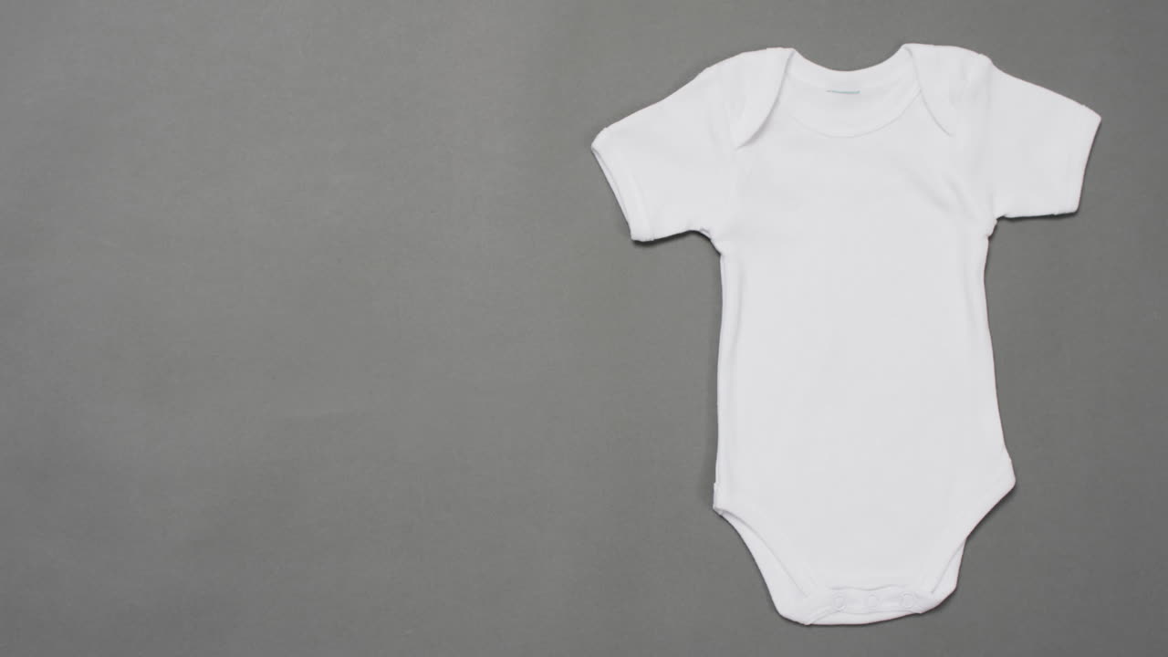Video of white baby grow with copy space on grey background