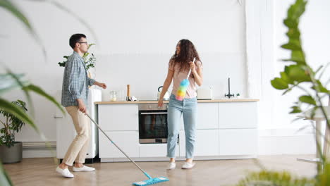 couple cleaning and dancing in kitchen