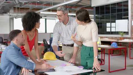 equipo de diversos arquitectos discutiendo sobre un plan en la oficina