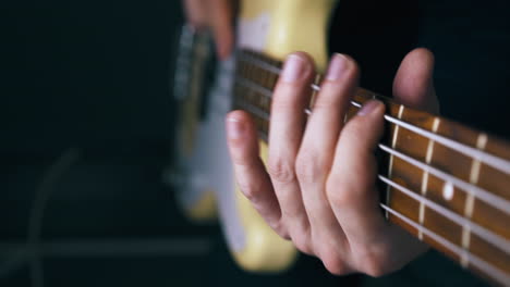 persona toca la guitarra baja cuerda de metal moviendo el dedo en los trastes