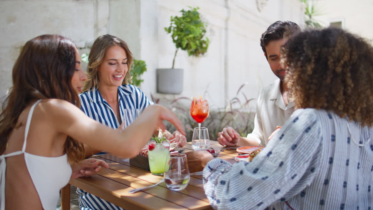 amigos riendo cenando en una cafetería al aire libre. gente positiva.