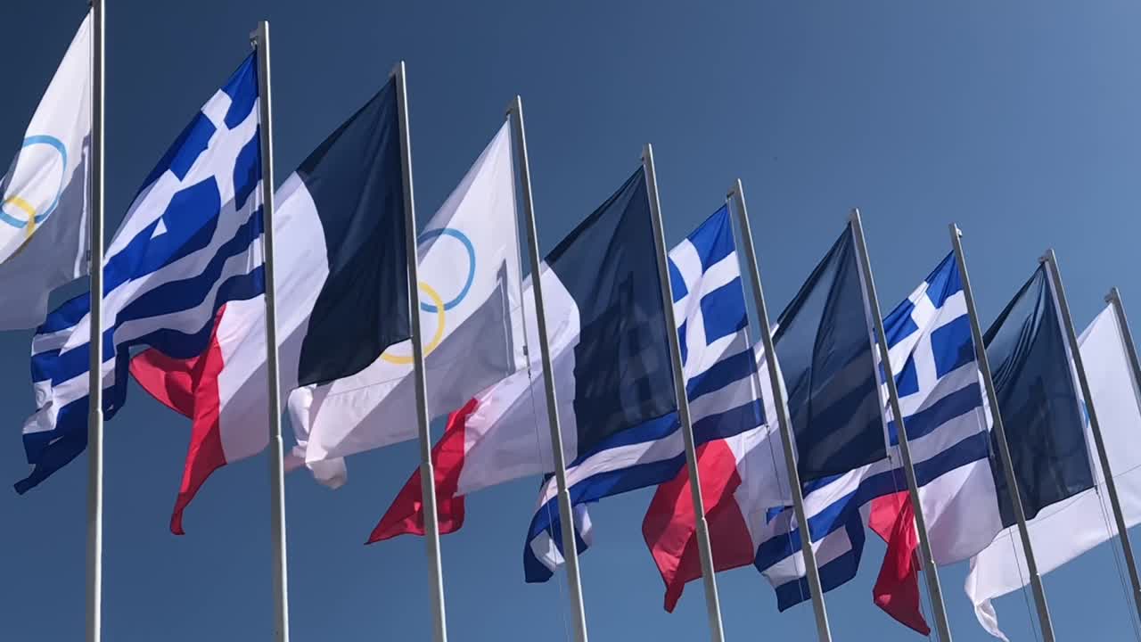 French, Greek and Olympic flags floating in the wind in slow motion during the opening ceremony of the Olympic flame