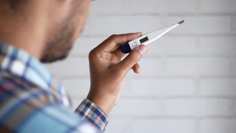 persona que comprueba la temperatura con un termómetro digital
