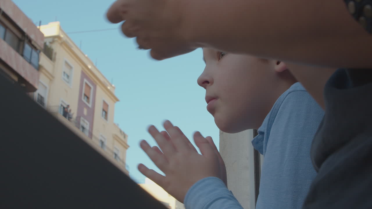 엄마와 아들은 코로나19 팬데 기간 동안 의료진에게 감사를 표하기 위해 박수를 치고 있습니다.