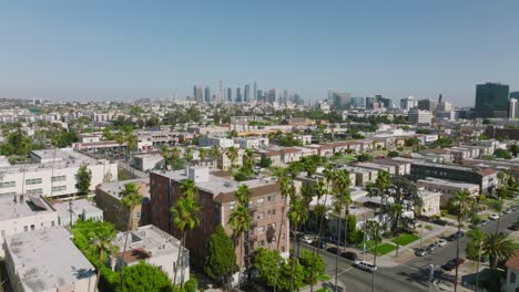 Drohnenaufnahme-Der-Wohngegend-Von-Los-Angeles-An-Einem-Sonnigen-Tag,-Downtown-La-Skyline-In-Der-Ferne-Am-Horizont