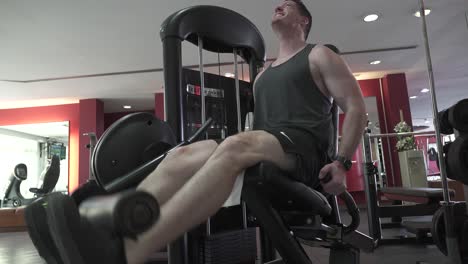 close-up shot of a man going to failure on a leg extension machine